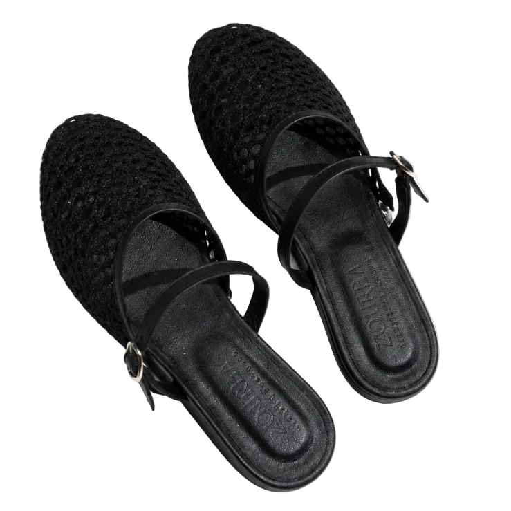 A pair of black woven mule sandals with thin straps and small buckle details, photographed from a top-down angle on a white background.